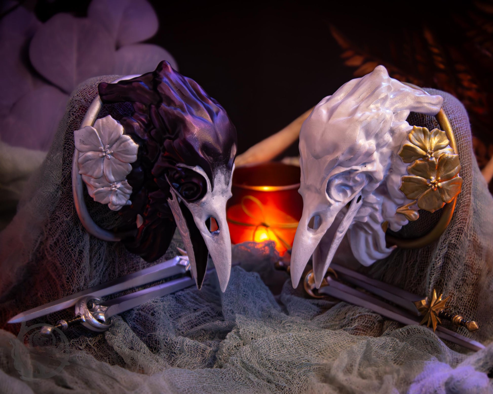Two resin hair bun covers set up on stands, with their resin sword pins. The bun covers are ravens with gilded geraniums.